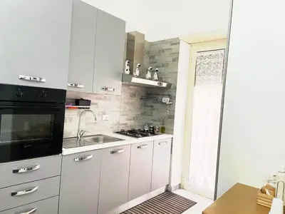 a white kitchen with a sink and a stove at Asia Guest House in Rome