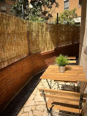a wooden table and bench next to a fence at Asia Guest House in Rome