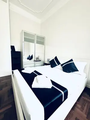 a bedroom with two large white beds with blue pillows at Santa Maria Maggiore Suites Apartments in Rome