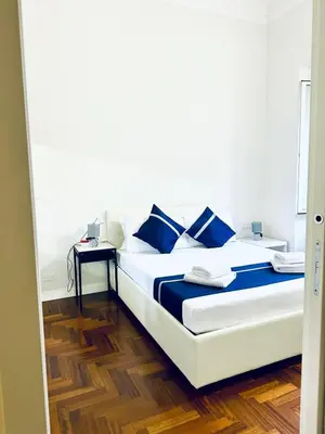 a white bed with blue pillows in a room at Santa Maria Maggiore Suites Apartments in Rome