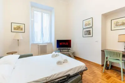a bedroom with a bed and a tv in it at Maison Villa Borghese in Rome