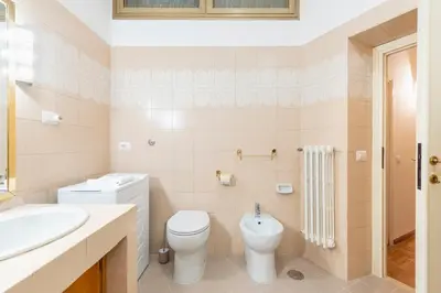 a white bathroom with a toilet and a sink at Maison Villa Borghese in Rome