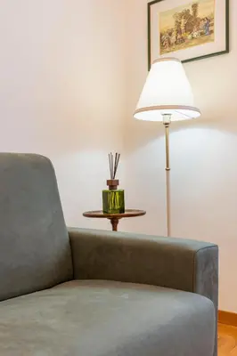 a living room with a couch and a lamp at Maison Villa Borghese in Rome