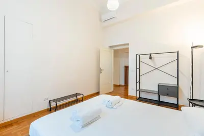 a bedroom with a white bed and a mirror at Maison Villa Borghese in Rome