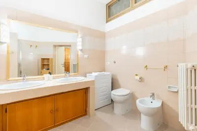a bathroom with two sinks and a toilet and a mirror at Maison Villa Borghese in Rome