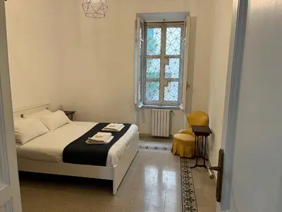 a bedroom with a bed and a window and a chair at Gianicolo Hill Apartment in Rome
