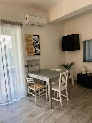 a dining room with a table and chairs and a tv at Casa Cycas in Rome