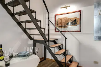 a black spiral staircase in a dining room with a table at Residenza Ripetta in Rome