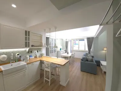 a kitchen and living room with a counter and a table at San Paolo Charme Apartment in Rome