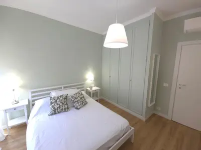a bedroom with a white bed with two pillows at San Paolo Charme Apartment in Rome