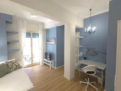 a bedroom with blue walls and a bed and a desk at San Paolo Charme Apartment in Rome