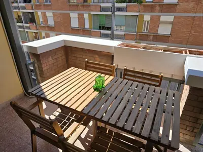 a wooden table and chairs on a balcony with a bench at San Paolo Charme Apartment in Rome