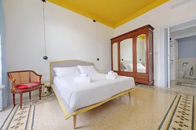 a bedroom with a large white bed and a chair at Modern retreat with Spectacular St Peter's views in Rome