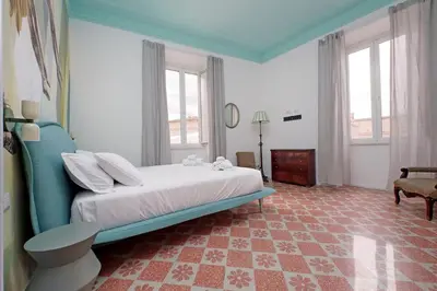 a bedroom with a bed and a table and windows at Modern retreat with Spectacular St Peter's views in Rome