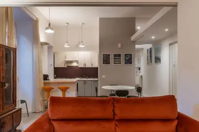 a living room with a couch and a kitchen at GuestHost Cozy Flat X4 - 450m to Vatican City! in Rome