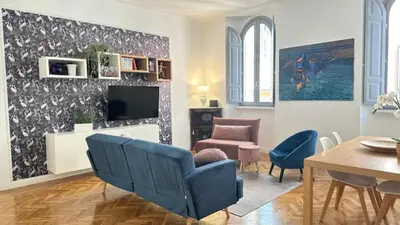 a living room with a blue chair and a tv at La bella vita Navona in Rome