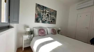 a bedroom with a white bed with pink pillows at La bella vita Navona in Rome
