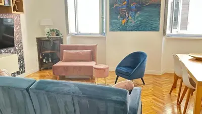 a living room with a blue couch and chairs at La bella vita Navona in Rome