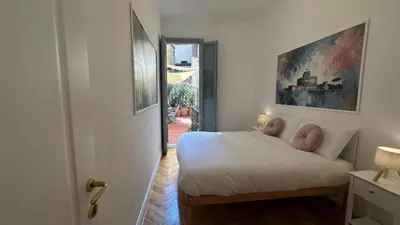 a bedroom with a white bed with pink pillows at La bella vita Navona in Rome