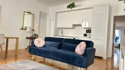 a living room with a blue couch with pink pillows at La bella vita Navona in Rome