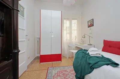 a bedroom with a bed and a desk and a red door at 4BNB - Annibaliano Metro Apartment in Rome