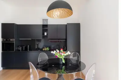 a dining room with a glass table and black cabinets at iFlat Stylish & Cozy Vatican Peaceful Gem in Rome