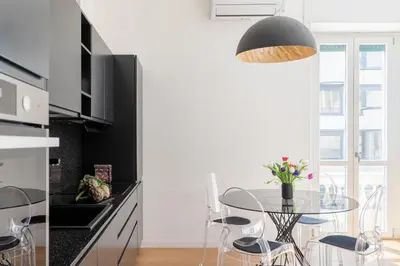 a kitchen with a table and chairs in a kitchen at iFlat Stylish & Cozy Vatican Peaceful Gem in Rome