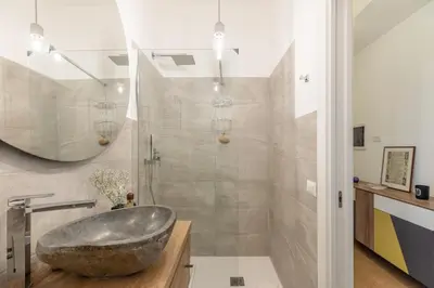 a bathroom with a large stone sink and a shower at iFlat Stylish & Cozy Vatican Peaceful Gem in Rome