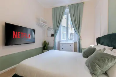a bedroom with a bed with a television on the wall at The 38 Home Exclusive - Homkeey Apartments in Rome