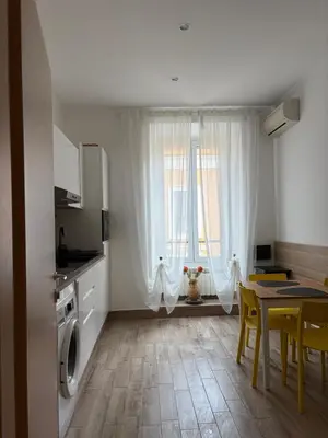 a kitchen and dining room with a table and chairs and a table and a kitchen at Dimora Vaticano Rome Apartments in Rome