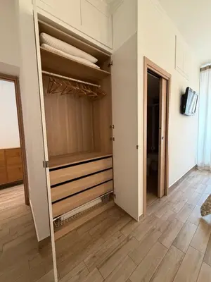 a walk in closet with wooden floors and a tv at Dimora Vaticano Rome Apartments in Rome
