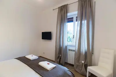 a bedroom with a bed and a chair and a window at Boba's House, Rome in Rome