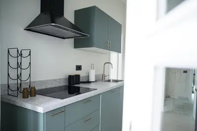 a kitchen with blue cabinets and a black hood at La Terrazza di Ermini in Rome