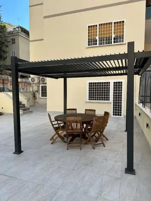 a patio with a table and chairs under awning at La Terrazza di Ermini in Rome