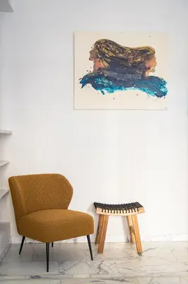 a chair and a table in a room with a painting at La Terrazza di Ermini in Rome
