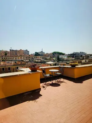 a patio with a table and chairs on a roof at Enzo House in Rome