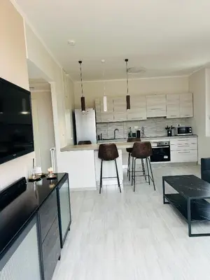 a kitchen with white cabinets and a table and chairs at Enzo House in Rome