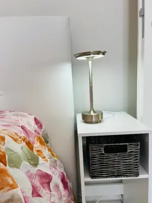 a lamp on a night stand next to a bed at Enzo House in Rome
