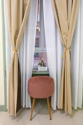 a chair sitting in front of a window with curtains at Mia House Prestige in Rome