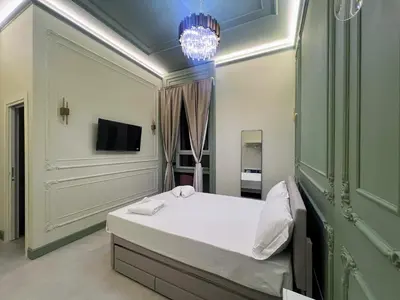 a bedroom with a bed and a chandelier at Mia House Prestige in Rome