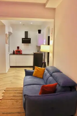 a living room with a blue couch and a flat screen tv at Alessi Home Pigneto in Rome