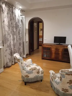a living room with two chairs and a television at Alloggio turistico Artù in Rome