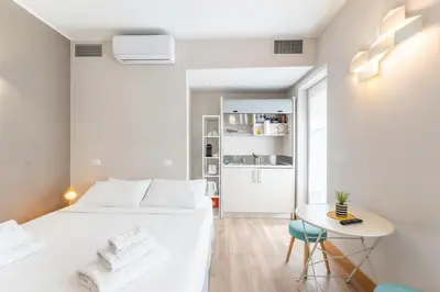 a white bedroom with a white bed and a table at Double Pixel Apartments - Wonderful Stay in Rome