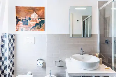 a bathroom with a sink and a painting on the wall at Double Pixel Apartments - Wonderful Stay in Rome