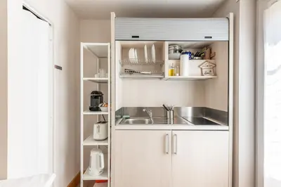 a kitchen with white cabinets and a sink at Double Pixel Apartments - Wonderful Stay in Rome