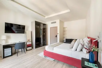 a bedroom with a bed and a desk and a television at Domus 28 in Rome