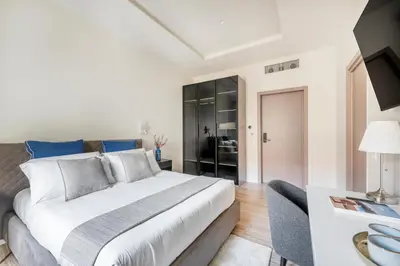 a bedroom with a large bed and a living room at Domus 28 in Rome