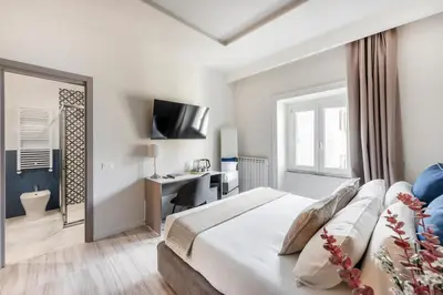 a bedroom with a bed and a desk and a mirror at Domus 28 in Rome