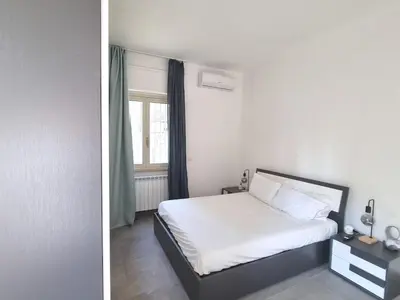 a bedroom with a white bed and a window at Pigneto Giardino e Posto Auto Privati in Rome