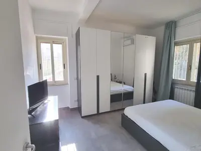 a bedroom with a bed and a cabinet with a television at Pigneto Giardino e Posto Auto Privati in Rome